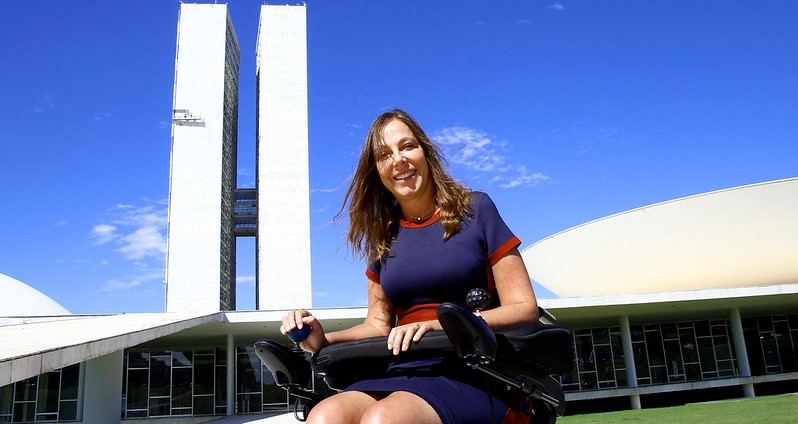 Mara posa sorrindo em frente ao Planalto central de Brasília