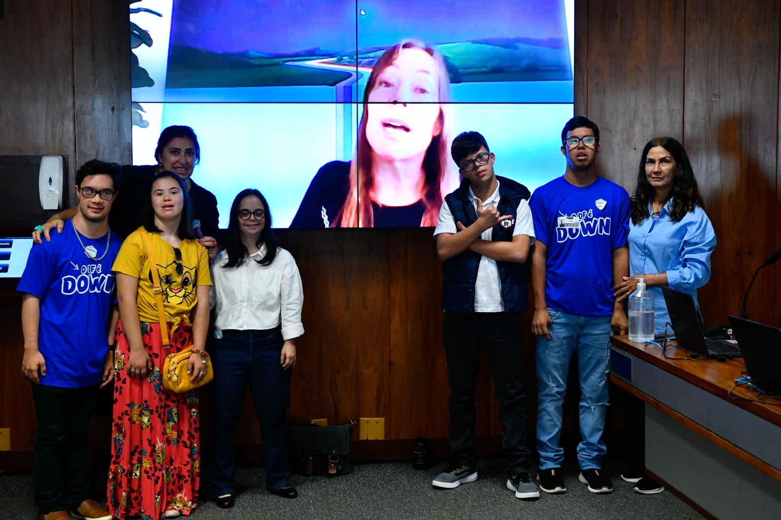 Na foto Mara aparece no telão da CCJ enquanto representantes e pessoas com Sindrome de Down das associações estão a frente presencialmente